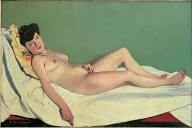 Mujer desnuda acostada sobre una sábana blanca, cojín amarillo