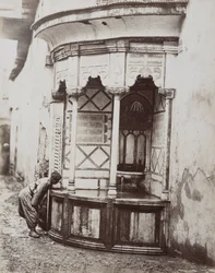 Un hombre bebiendo de una fuente de esquina, en una calle de Damasco, Siria