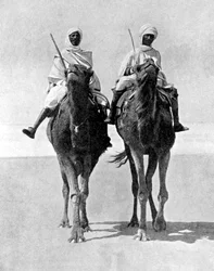 Dos árabes montando camellos en el desierto del Sahara, África, 1936