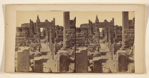 [Ruinas con figuras talladas en las paredes en primer plano]