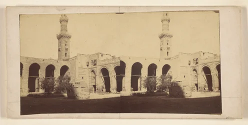 [Vista del edificio con torre alta, tumba en el patio]