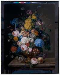 Rosas, lirios, claveles, tulipanes y otras flores en una urna de bronce
