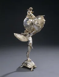 Un florero escultórico de bronce electrochapado W.M.F., diseñado por Franz von Stuck, modelado como un joven alado de pie sobre una tortuga, sosteniendo en alto una concha de nautilus, c.1906