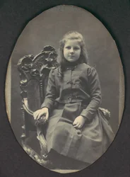 [Niña con Rizos, Sentada, Tres Cuartos de Longitud], 1890s