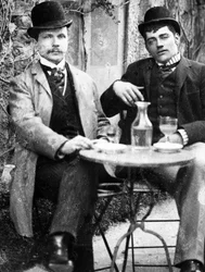 Un chatelain (Ducos) y su cochero sentados en la terraza de un café bebiendo absenta - fotografía, circa 1890