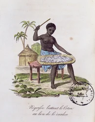 Mujer africana golpeando algodón