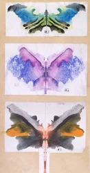 Mariposas hechas doblando papel coloreado por la mitad usadas en un juego de salón