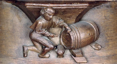 Escultura que representa a un hombre poniendo un grifo en un barril, de un coro de la Abadía de San Lucien en Beauvais