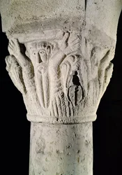 Capitel de columna con un hombre con los brazos levantados
