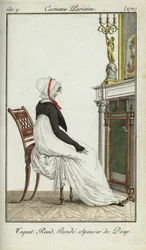 Mujer a la moda sentada frente a una chimenea