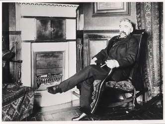 Stéphane Mallarmé (1842-98) sentado junto a la chimenea en su casa en la Rue de Rome, París
