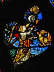 La ventana rosa oeste que representa una escena del Libro de Apocalipsis: cuarta trompeta, sol, luna y estrellas oscureciéndose, y el águila como el ángel gritando Ay, Ay, escrito debajo (8:12-13)