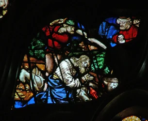 La ventana rosa oeste que representa una escena del Libro de Apocalipsis: dos testigos son puestos a muerte con una figura con turbante observando (11:3-11)