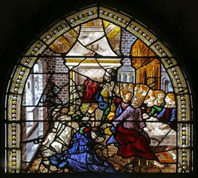 Ventana w16 que representa a Santo Tomás en India invitado a la boda de Pelagio, golpeado por un sirviente que a su vez es devorado por un león. Un perro trae el brazo del sirviente