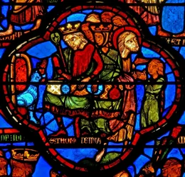 Ventana w16 que representa una escena de la vida de Santo Tomás: el santo en un banquete de bodas para la hija del rey de la India es abofeteado por un copero: un león le quita el brazo; Tomás restaura