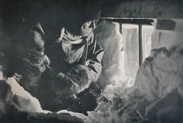 Despejando la nieve de la ventana de la cabaña en Cabo Adare, c1911