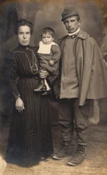 Postal con un soldado de infantería, artillero, en el uniforme de guerra con su familia, 16031917