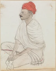Hombre con turbante rojo sentado con las piernas cruzadas