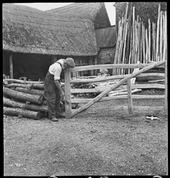Un hombre haciendo una puerta de campo en el pueblo de Aston