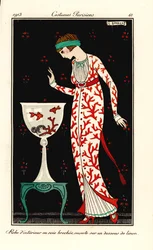 Mujer con vestido de casa de seda con estampado de coral sobre una enagua de lino. Acuario con coral y peces de colores. Bata de casa en seda brocada, sobre una enagua de lino. Grabado pochoir (stencil) coloreado a mano según una ilustración de George Barb