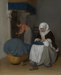 Mujer cosiendo junto a una cuna