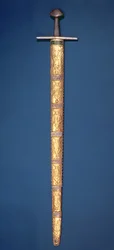 Espada Imperial de los Emperadores del Sacro Imperio Romano con pomo y barra transversal parcialmente dorados, la empuñadura envuelta en alambre de plata y la vaina compuesta por catorce placas de oro
