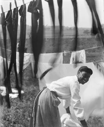 Una joven afroamericana colgando ropa para secar en Newport, Rhode Island, c.1902