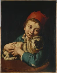 Un niño, medio cuerpo, con chaqueta azul y sombrero rojo, sosteniendo un pug sobre un cojín