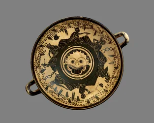 Copa de figuras negras áticas decorada con un tondo de cabeza de Gorgona rodeado por seis hombres reclinados asistiendo a un simposio, al estilo del Pintor de Andócides, c.500 a.C.