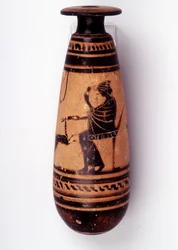 Pintura en jarrón: alabastro usado para contener perfume: una cara representa a una mujer jugando con una cierva y sosteniendo una flor. Su cesta para la lana está detrás de ella. 500 a.C. BNF, Oficina de Medallas