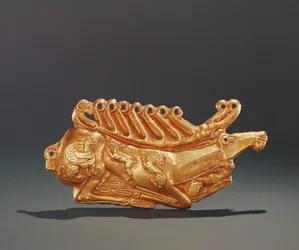 Ciervo recostado, decorado en el cuerpo con figuras de grifo alado, liebre, león, perro y cabeza de carnero