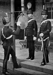 Golpeando el gong en la puerta principal de los cuarteles de caballería de Aldershot, Hampshire, 1896