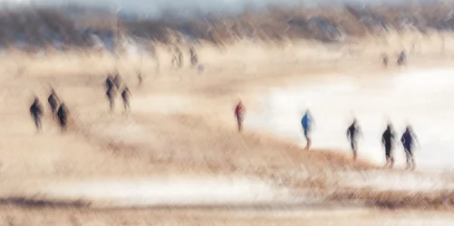 Paseantes en la playa difuminados