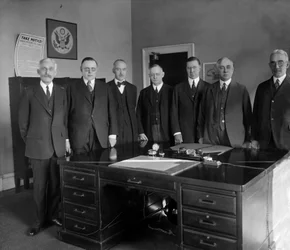 Junta de la Reserva Federal, de izquierda a derecha: Secretario Mellon; W.P.G. Harding; Vicegobernador Edmund Platt; Charles S. Hamlin; Adolph Miller; Interventor D.R. Crissinger, y J.R. Mitchell. Fotografía de Harris & Ewing, c. 1905 / 1945.