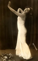 Retrato de la actriz francesa Regina Badet en una pose evocadora, con un largo vestido blanco.