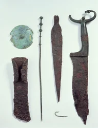 De arriba a abajo: cuchillo, punta de lanza, anzuelo, pinza de ropa, disco de cinturón y hacha, todos encontrados en tumbas masculinas en Hallstatt, Edad de Hierro