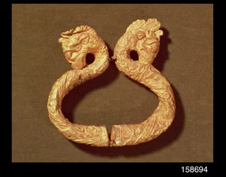 Brazalete con dos cabezas de monstruo, siglo XIV-XV (madera)