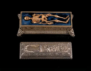 Esqueleto humano en miniatura y sarcófago