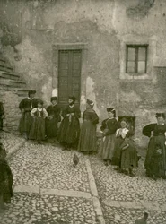 Mujeres y niños con trajes tradicionales en la escalera de acceso a una casa, Abruzos, Italia