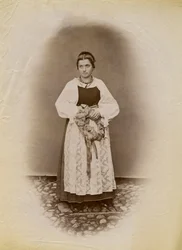 Joven con vestido de novia y sosteniendo un anillo de pan envuelto en cinta, Parre, Lombardía, Italia