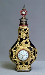 Frasco de perfume con reloj y brújula