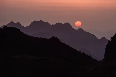 Un brillante sol carmesí anaranjado se pone sobre la cordillera de Yan Shan. Paso de Shanhaiguan, H...