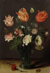 Tulipanes con otras flores en un vaso sobre una mesa