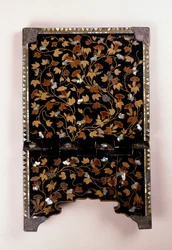 (detalle) del reverso de un atril misal cristiano del período Momoyama decorado con vides y follaje en aogai y oro hiramakie sobre un fondo roironuri