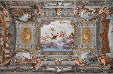 Banquete de bodas. En las nubes, Baco, Ariadna y Venus, con una figura que sirve vino, están sentados a una mesa redonda. Los demás dioses observan desde lejos.