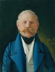 Caballero de abrigo azul y chaleco blanco.