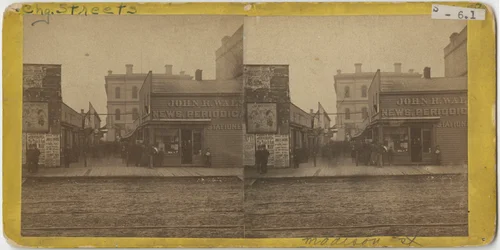 Vista de la tienda de periódicos de John R. Walsh en Madison Street, Chicago con la oficina de correos al fondo, 1869