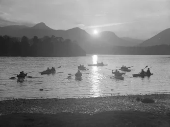 Vista de la gente navegando en canoa en Derwentwater al amanecer o al atardecer