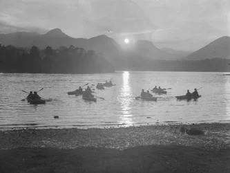 Vista de la gente navegando en canoa en Derwentwater al amanecer o al atardecer