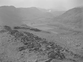 Vista de un valle abierto en Hardknott con montones de rocas en primer plano